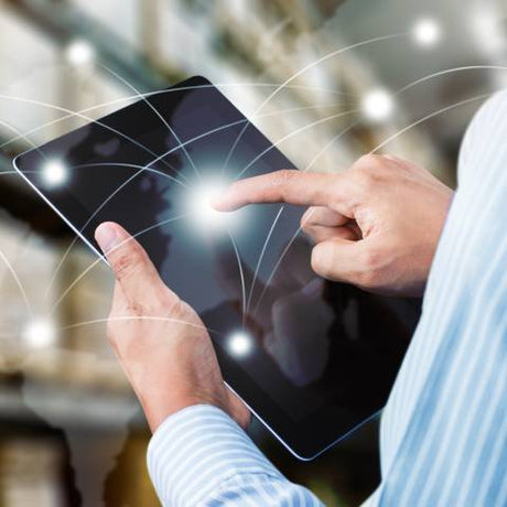 A close-up of a man's hands typing on a black tablet computer with white lines shooting out to symbolize fast delivery.